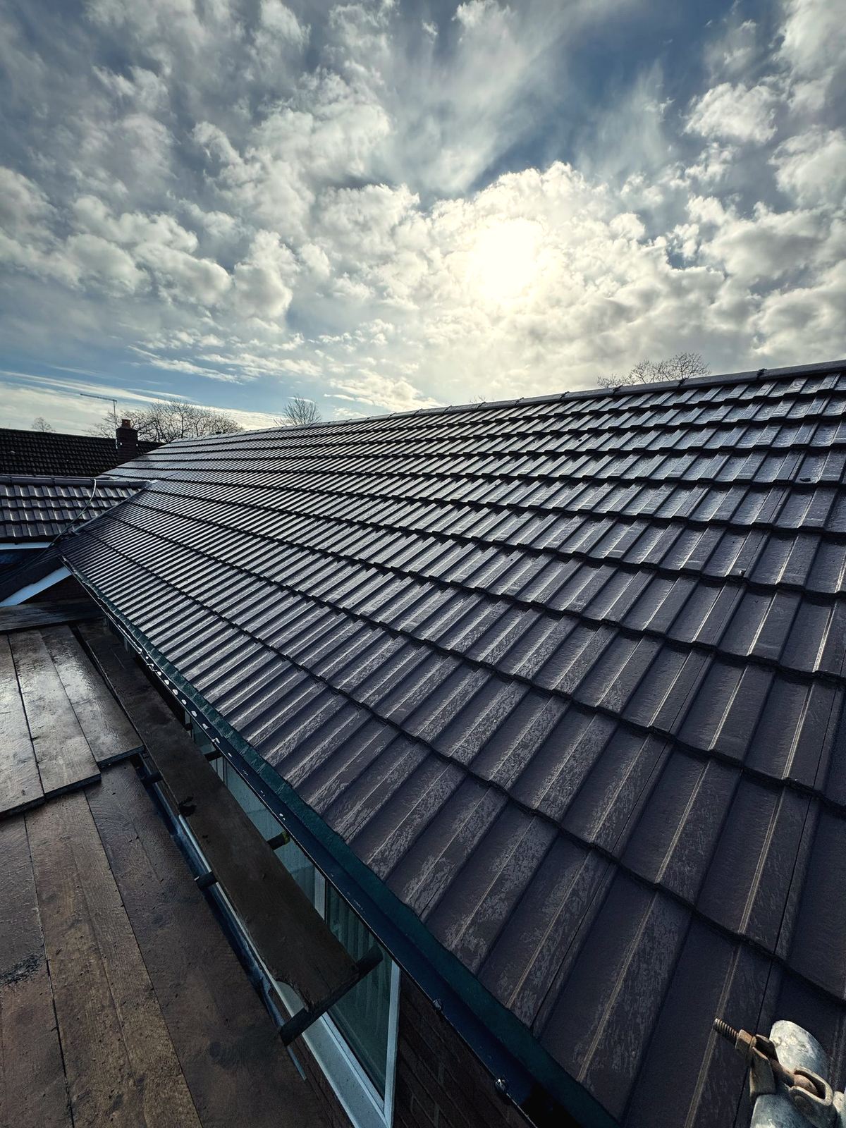 New dark tile roof under a dramatic Cheshire sky