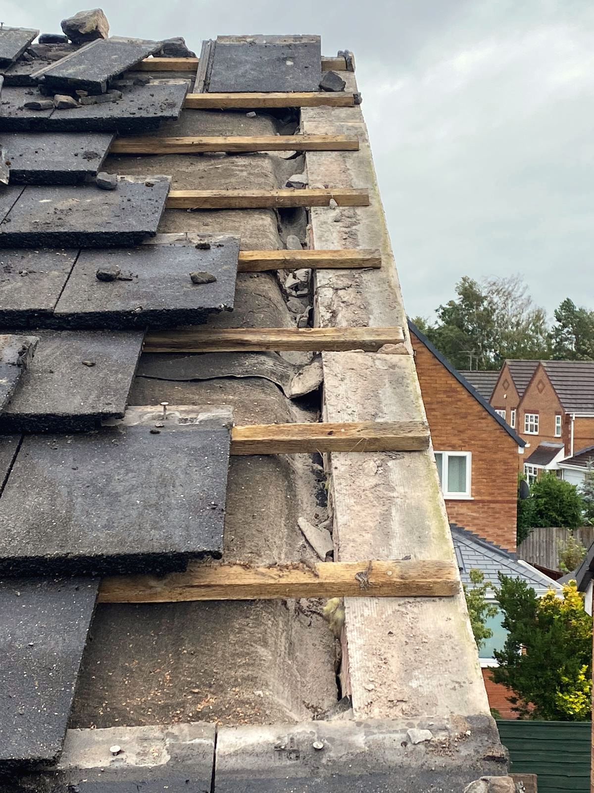 Damaged roof stripped back to battens for repair