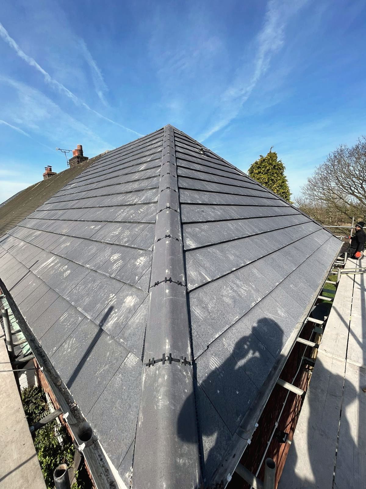 Slate hip roof against a blue sky